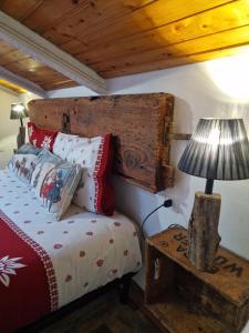 a bedroom with a bed and a table with a lamp at B&B Le Ciaf in Temù