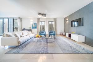 a living room with a white couch and blue chairs at Art Apartment In Mamila - Mamila Residence in Jerusalem