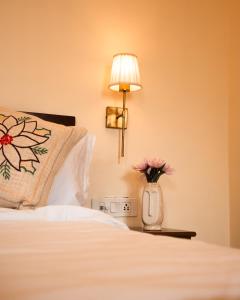 a hotel room with a bed with a vase of flowers at Banana Hostel Pushkar in Pushkar