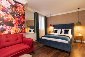 une chambre avec un lit et un canapé rouge dans l'établissement Lambrina Boutique rooms, à Plovdiv