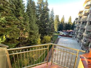 a balcony with a view of trees and buildings at FLORA Apartment Hotel 412 in Borovets