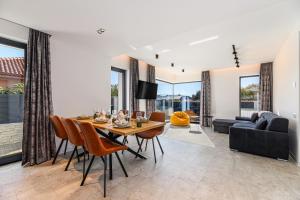 a dining room with a table and chairs and a couch at KOA - Nest in Braşov