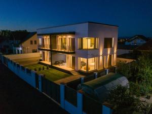 a large white house at night with lights at KOA - Nest in Braşov