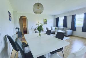 a white dining room with a white table and chairs at Banpim apartment with Jacusszi in Gravdal