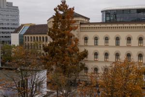 a tall building with a tree in front of it at HLN APARTMENTS Am Bahnhof in Saarbrücken