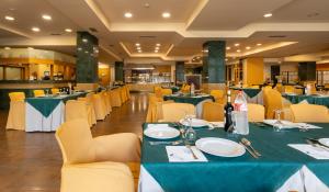 a dining room with green tables and yellow chairs at Hotel Felisa SPA in Queveda