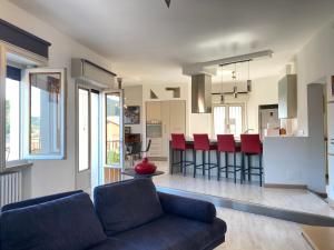 a living room with a blue couch and a kitchen at Appartamento Casa Anna in Garda