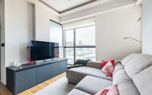 a living room with a couch and a flat screen tv at Apartamento céntrico y moderno con vistas a la Ría in Vigo