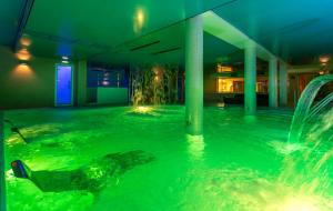 a swimming pool with a fountain in a building at Hotel Felisa SPA in Queveda