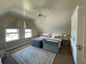 a attic bedroom with two beds and two windows at Precious, Peaceful 3bedroom, 6 sleeper family home! in Balfour