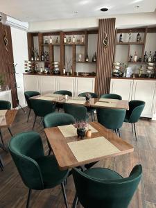 a restaurant with wooden tables and green chairs at Freedom&Relax in Buzău