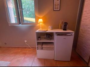 a small white kitchen with a table and a stove at Pépite du Maquis in Porto-Vecchio