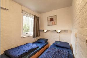 ein kleines Zimmer mit zwei Betten und einem Fenster in der Unterkunft Bungalowpark Simpelveld - Schakel 24 in Simpelveld