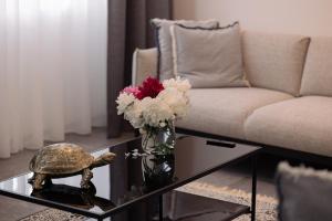 a living room with a couch and a vase of flowers on a table at Suite Nr 5 - J26 LUXURY APARTHOTEL, Jauniela 26 Old Riga - Great View & Top Location - 2 Bedrooms - 80 m2 in Rīga