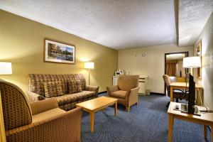 MillinocketにあるKatahdin Inn & Suitesのソファと椅子、リビングルームが備わるホテルルームです。