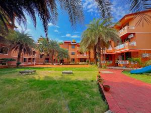 a building with palm trees and a playground at Jack & Rose Stays in Orlim