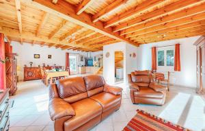 ein Wohnzimmer mit einem Ledersofa und Stühlen in der Unterkunft Nice Home In Louvie-Soubiron in Louvie-Soubiron