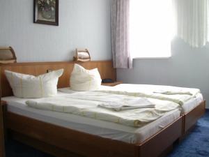 a bed with white sheets and pillows in a room at Hotel-Restaurant Marcus in Malchin +17 photos