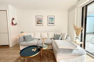 una sala de estar con un sofá y una mesa en Lovely ! T3 de standing - Proche bourg et plages, en Ploemeur