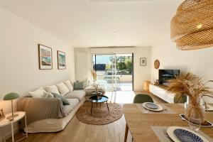 una sala de estar con un sofá y una mesa en Lovely ! T3 de standing - Proche bourg et plages, en Ploemeur