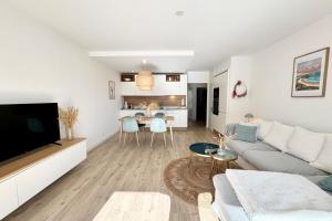 Una sala de estar con un sofá y un televisor. en Lovely ! T3 de standing - Proche bourg et plages, en Ploemeur 18 fotos más