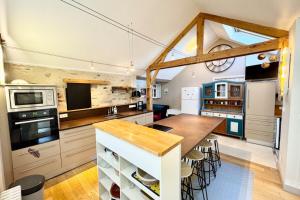 a kitchen with a table and some chairs in it at Spacieuse longère archi cosy - Jardin in Quimperlé