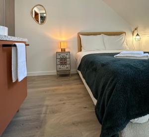 a bedroom with a bed and a table with a lamp at L'Écrin de Jaude - Duplex by PRIM0 C0NCIERGERIE in Clermont-Ferrand