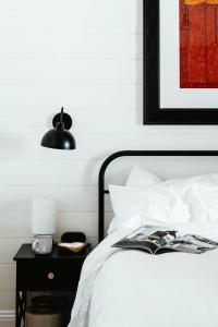 a bedroom with a bed and a table with a lamp at Benambra Cottage c1860 in Queenscliff