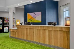 a lobby with a reception counter with green carpet at Spark by Hilton Daleville Roanoke North in Daleville