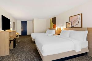 a hotel room with two beds and a television at Spark by Hilton Daleville Roanoke North in Daleville +22 photos