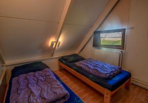 ein Dachzimmer mit zwei Betten und einem Fenster in der Unterkunft Bungalowpark Simpelveld - Alpha 105 in Simpelveld