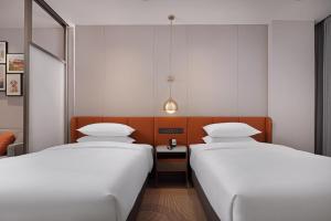 Rúm í herbergi á Home2 Suite by Hilton Chengdu Pengzhou