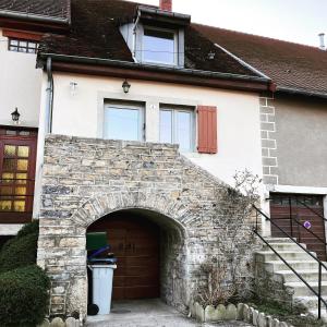 una casa con un arco delante de un garaje en Maison Rosie, en Voiteur