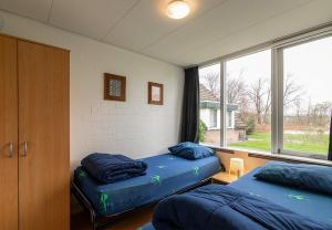 two beds in a room with a window at Bungalowpark Simpelveld - Delta 142 in Simpelveld