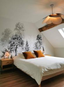 Un dormitorio con una gran cama blanca con almohadas naranjas. en Maison Rosie, en Voiteur