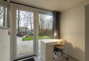 a room with a desk and a sliding glass door at Bungalowpark Simpelveld - Delta 126 in Simpelveld