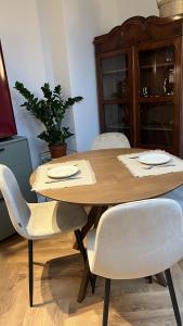 a wooden table with white chairs and a wooden cabinet at Le Cœur de la Ville in Poznań +15 photos