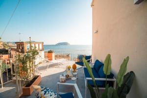 a balcony with blue chairs and a view of the ocean at Villino Castriota Scanderbeg in Pozzuoli