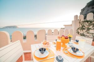 a table with food and a view of the ocean at Villino Castriota Scanderbeg in Pozzuoli