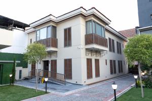 BucaKocabıçak Buca Hotel的白色的建筑,带有棕色百叶窗