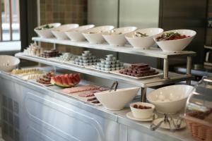 a buffet line with plates and bowls of food at Kocabıçak Buca Hotel in Buca