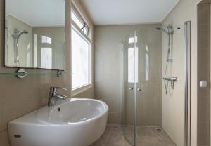 a bathroom with a sink and a glass shower at Bungalowpark Simpelveld - Delta 118 in Simpelveld
