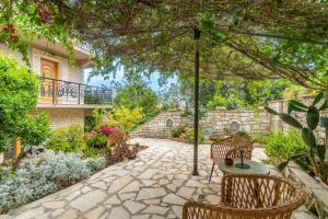 a patio with a table and chairs and an umbrella at Paxi Apt in Gaios