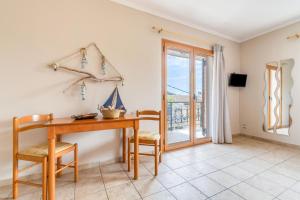 a dining room with a table and chairs and a window at Paxi Apt in Gaios +20 photos