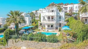 een groot wit huis met een zwembad en palmbomen bij Vintage Villa in Bodrum City