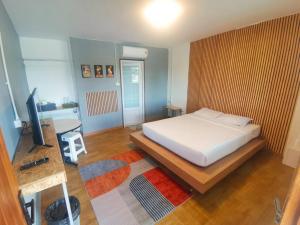 a bedroom with a bed and a television in it at นอนเบาเบารีสอร์ท in San Pa Tong