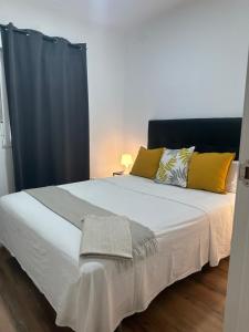 Un dormitorio con una gran cama blanca con almohadas amarillas. en Oporto 26, en Madrid