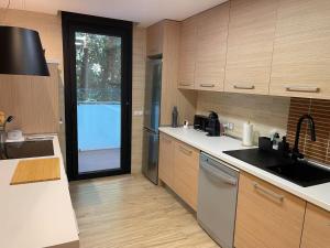 a large kitchen with wooden cabinets and a large window at La avellaneda in Arenas de San Pedro +2 photos