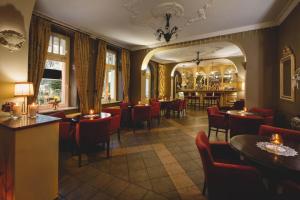 a restaurant with red chairs and tables and a bar at Amalia - noclegi i restauracja in Kudowa-Zdrój