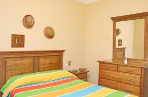 a bedroom with a bed and a dresser and a mirror at Casa familiar Palmar in El Palmar +11 photos